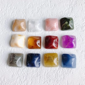 Detailed grid of twelve square resin marble charms for DIY jewelry and phone case crafts