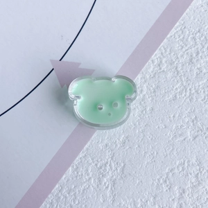 Detail view of a mint green resin bear charm with a smooth glossy texture for DIY crafts