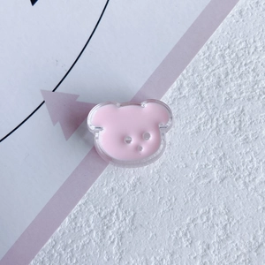 Close-up of pink resin bear DIY accessory with transparent edges and three holes