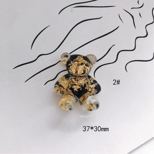 Macro shot of 37x30mm DIY teddy bear charm with gold foil flakes in black resin