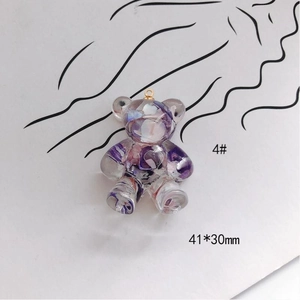 Detail of a 41x30mm acrylic bear pendant with purple petals and gold metal ring