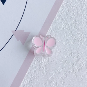 Vue rapprochée d'une breloque papillon en résine rose pour accessoires cheveux DIY