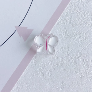 Vue détaillée d'un accessoire papillon en résine avec détails de couleur blanc et rose