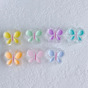 Vue détaillée des accessoires papillon en résine colorée en sept tons pastel pour bijoux de cheveux