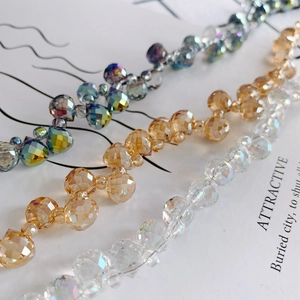 Close-up of faceted crystal teardrop beads in iridescent, champagne, and AB white colors