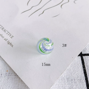 Macro detail of 15mm hollow glass bead with blue and green spiral texture for DIY jewelry