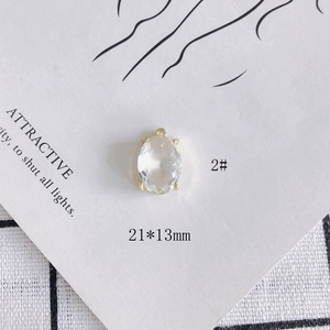 Detailed view of 21x13mm oval clear crystal pendant with golden claw setting and loop