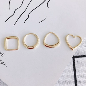 Set di quattro anelli geometrici in lega placcati oro con forme quadrate tonde e cuore