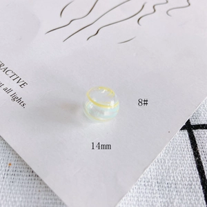 Close-up of 14mm hollow glass bead with yellow and blue spiral patterns for DIY jewelry