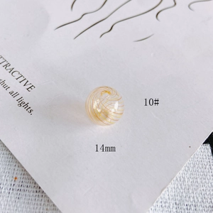 Detail of 14mm hollow glass bead with orange spiral pattern for DIY jewelry making