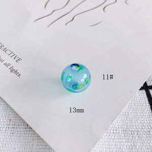 Macro shot of 13mm light blue hollow glass bead with artistic dark blue and green spots