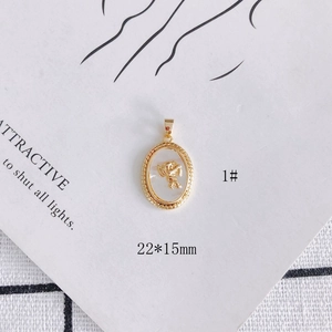 Detail view of 18k gold plated shell pendant with angel relief, size 22x15mm