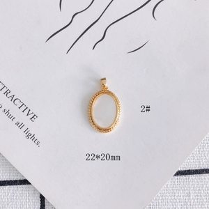 Macro detail of 22x20mm gold-plated oval frame pendant with intricate textured edges