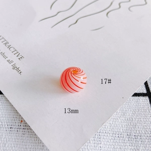 Macro view of 13mm smooth glass hollow bead with red spiral pattern for DIY jewelry