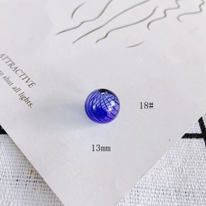 Macro view of a 13mm blue transparent ripple hollow glass bead with black grid lines