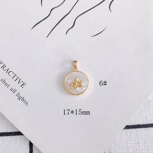 Macro view of a 17x15mm 18k gold plated shell pendant with an angel relief detail