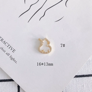 Macro view of 16x13mm gold-plated gourd pendant with zircons and star details
