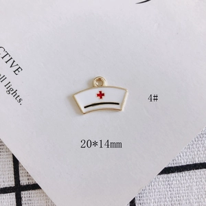 Detailed view of white nurse hat charm with red cross and size label 20x14mm