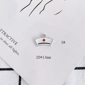 Macro detail of enamel nurse hat charm with red cross for DIY jewelry making