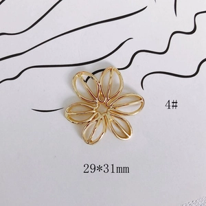 Vista detallada de un colgante de flor hueca dorada de 29x31mm para joyería DIY