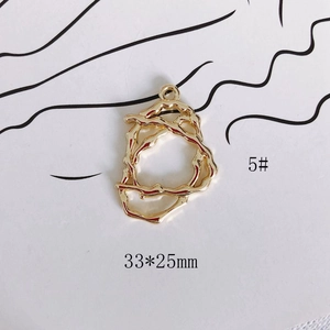 Primer plano del colgante de flor hueca irregular dorado con medidas de 33x25mm