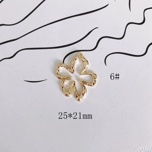 Detalle de un colgante de flor dorada de 25x21mm con textura martillada para joyería DIY