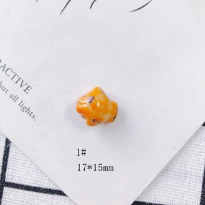 Detail shot of a 17x15mm orange ceramic fish bead with a glossy handmade finish