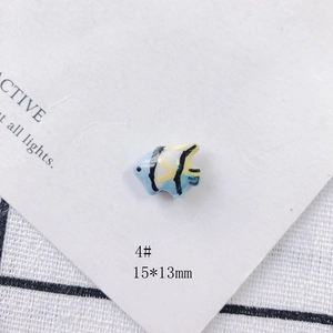 Macro detail of 15x13mm light blue tropical fish ceramic bead for DIY jewelry making