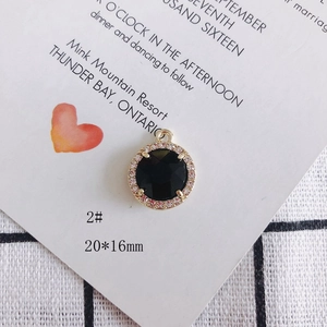 Detalle del colgante redondo dorado de 20x16mm con piedra negra y pedrería brillante