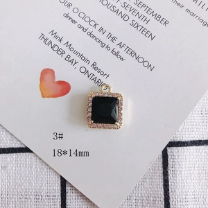 Detalle de un colgante cuadrado de piedra negra de 18x14mm con borde de cristal rosa