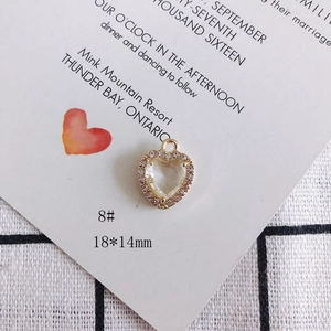 Detalle de colgante de corazón chapado en oro con cristal transparente y piedras rosas