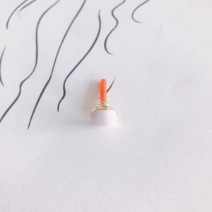 Makroaufnahme von rosa geometrischen Ohrring-Zubehör mit Goldring und orangefarbenem Stift