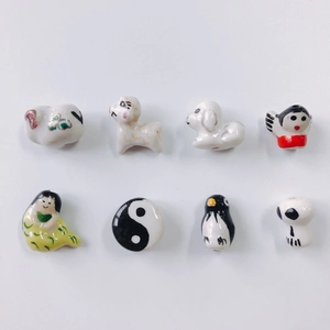 Macro detail of eight assorted hand-painted ceramic charms featuring cute animal shapes