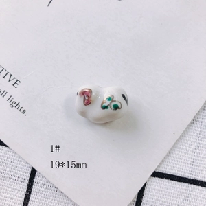 Macro shot of 19x15mm handmade ceramic oval bead with pink floral and gold accents