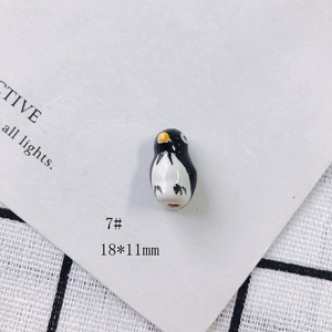 Detail of 18x11mm penguin ceramic pendant with smooth glaze for DIY jewelry making