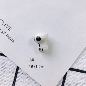 Detail shot of a white skull ceramic charm measuring 16x12mm for DIY jewelry making