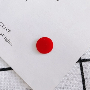 Macro-opname van een 15mm rode ronde acryl bedel met gaatje voor DIY sieraden maken