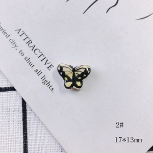 Detailed macro view of a 17x13mm yellow ceramic butterfly bead for DIY jewelry making