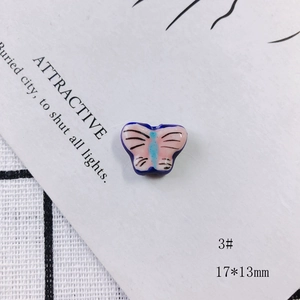 Macro detail of 17x13mm colorful ceramic butterfly bead for DIY jewelry making