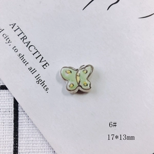 Macro shot of 17x13mm light green ceramic butterfly bead with yellow dots for DIY jewelry