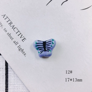 Macro detail of a 17x13mm handmade purple ceramic butterfly bead for DIY jewelry craft