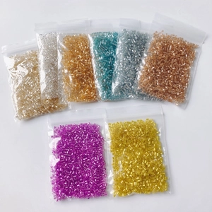 Macro shot of colorful 2mm silver-lined bugle beads in seven organized plastic bags
