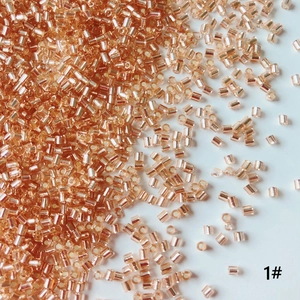 Detailed macro view of 2mm rose gold glass tube beads for DIY jewelry making and crafts