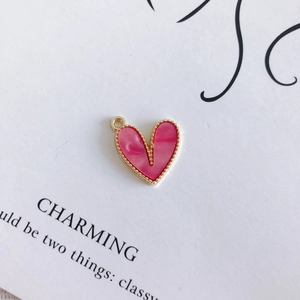 Dettaglio di pendente a cuore in marmo rosa con bordi dorati per creazione di gioielli