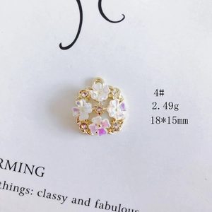 Detailed close-up of a floral wreath pendant with purple flowers and a central crystal