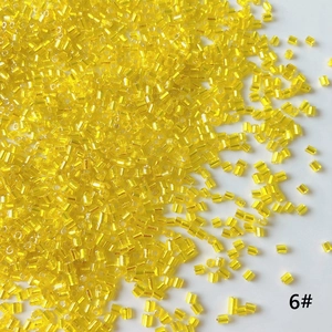 Detailed view of 2mm transparent yellow glass bugle beads for DIY jewelry making