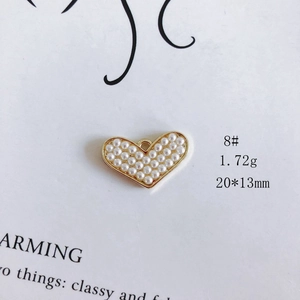 Detailed macro view of a heart pendant featuring elegant pearls and gold plating