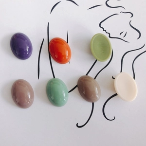 Set of seven colorful oval resin cabochons for DIY accessories on artistic background