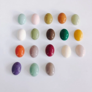 Flat lay of 18 colorful oval acrylic cabochon beads for DIY shoe charms and accessories