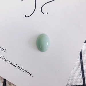 Detailed view of oval light green aventurine stone with polished smooth glossy finish